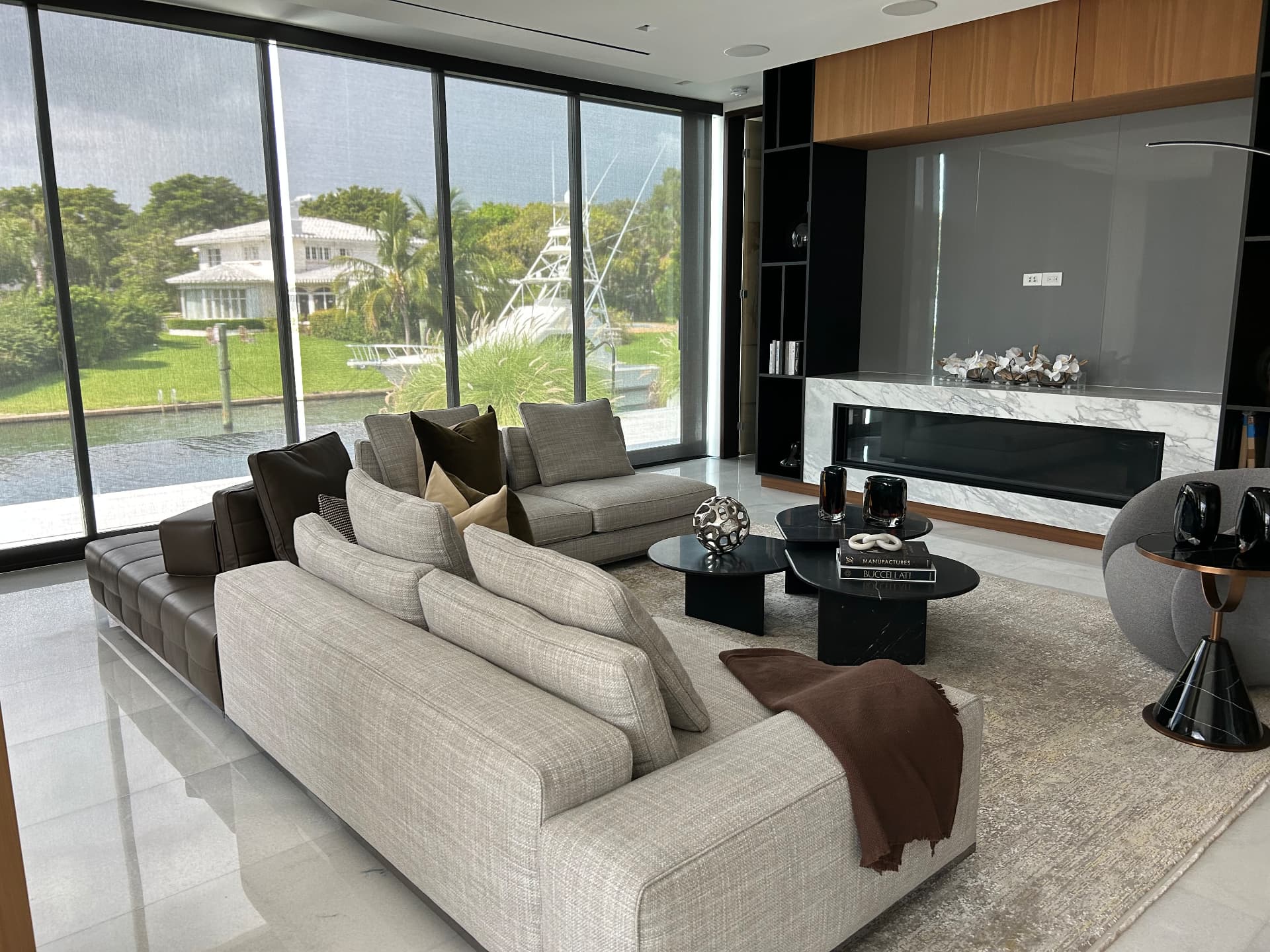 Waterfront estate living room with solar shades over canal-facing glazing