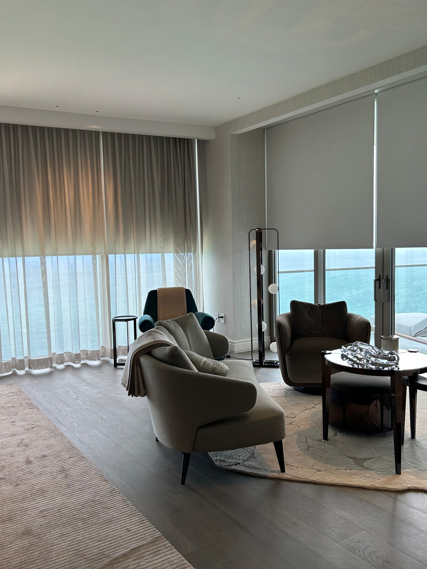 Estate at Acqualina sitting area with a lowered room-darkening shade and sheer drapery