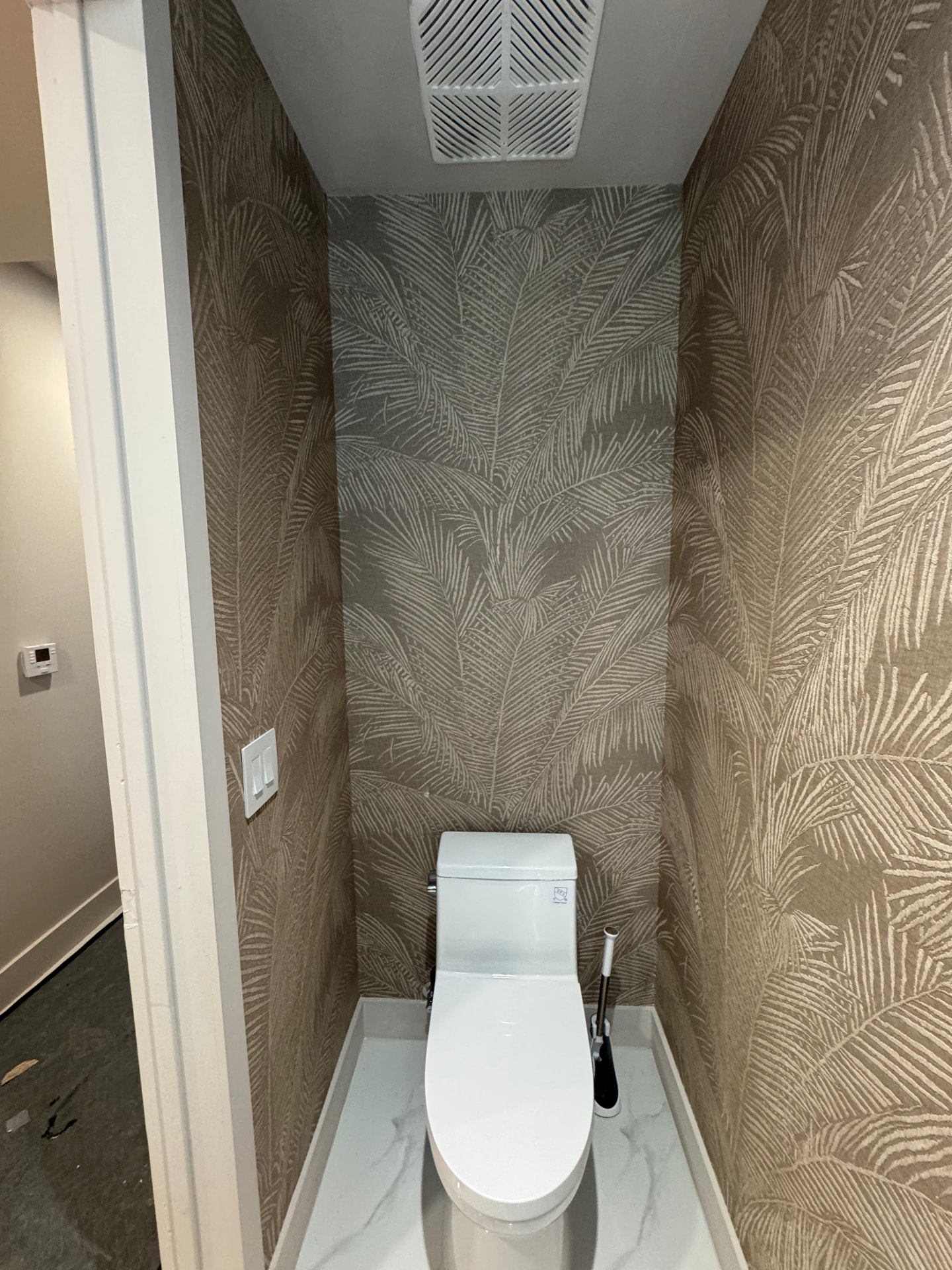 Aria Reserve powder room wrapped in palm leaf wallcovering