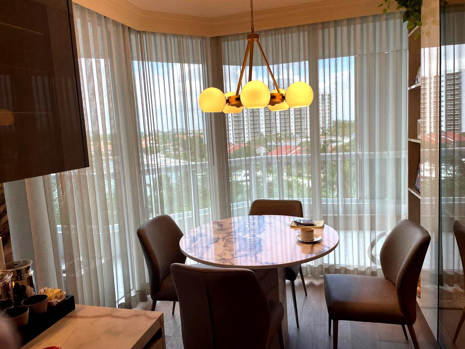 Casabella breakfast area with sheer drapes around angled glass