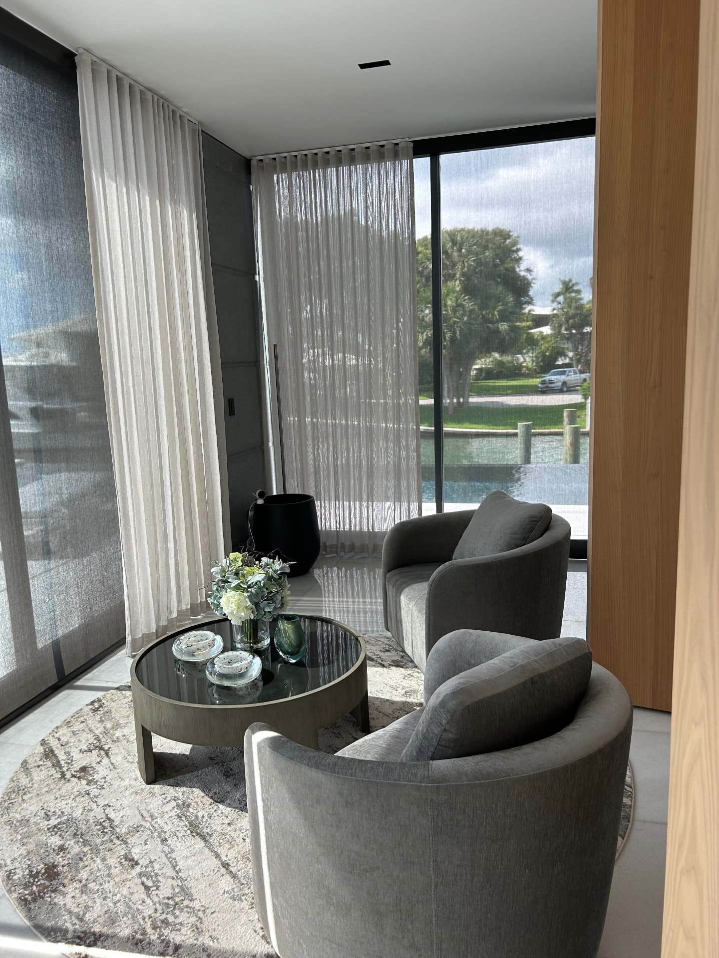 Waterfront estate seating corner with full-height sheer drapery facing the water