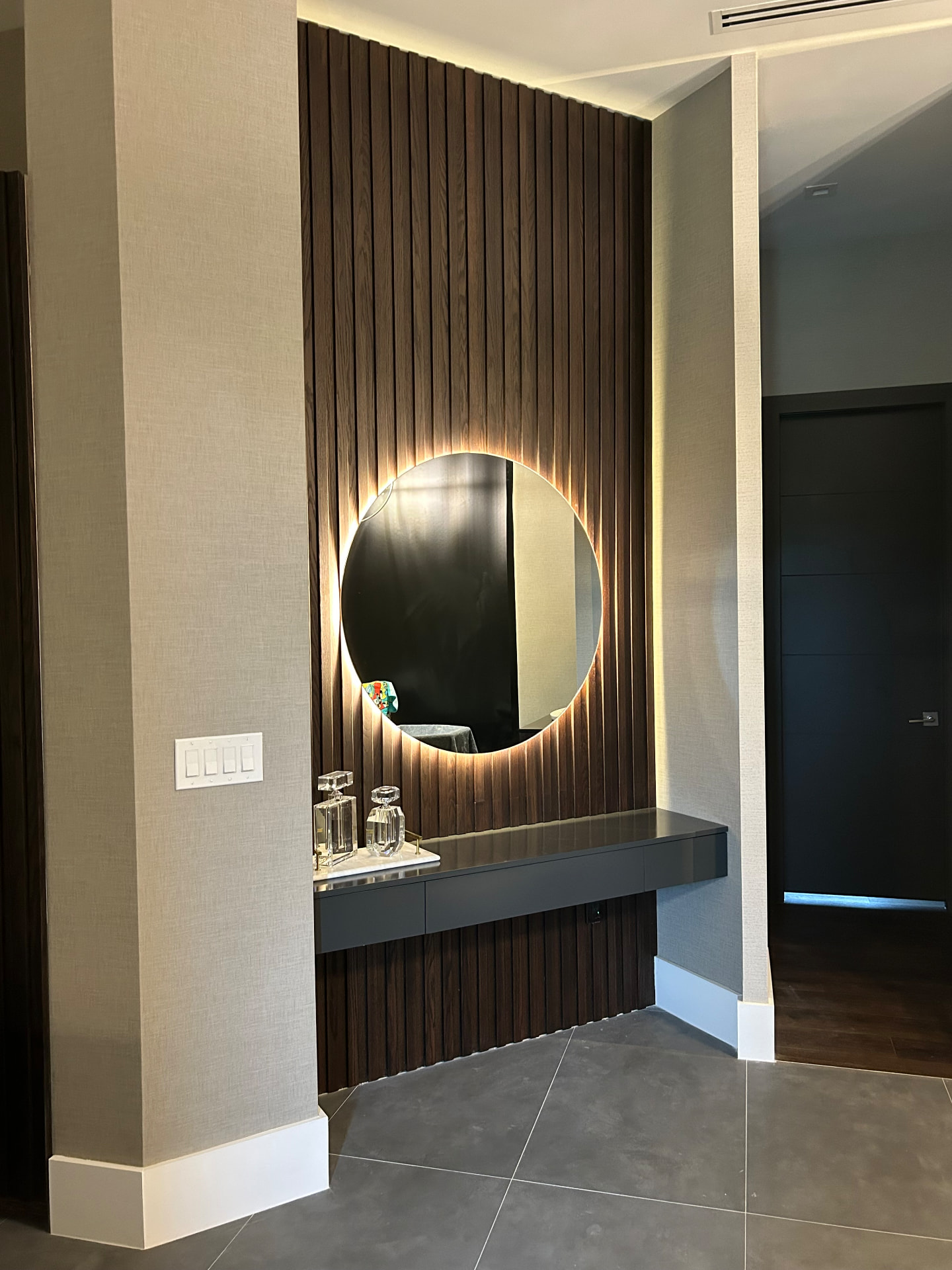 Southwest Ranches dressing nook with slatted wood wall, backlit mirror and floating vanity